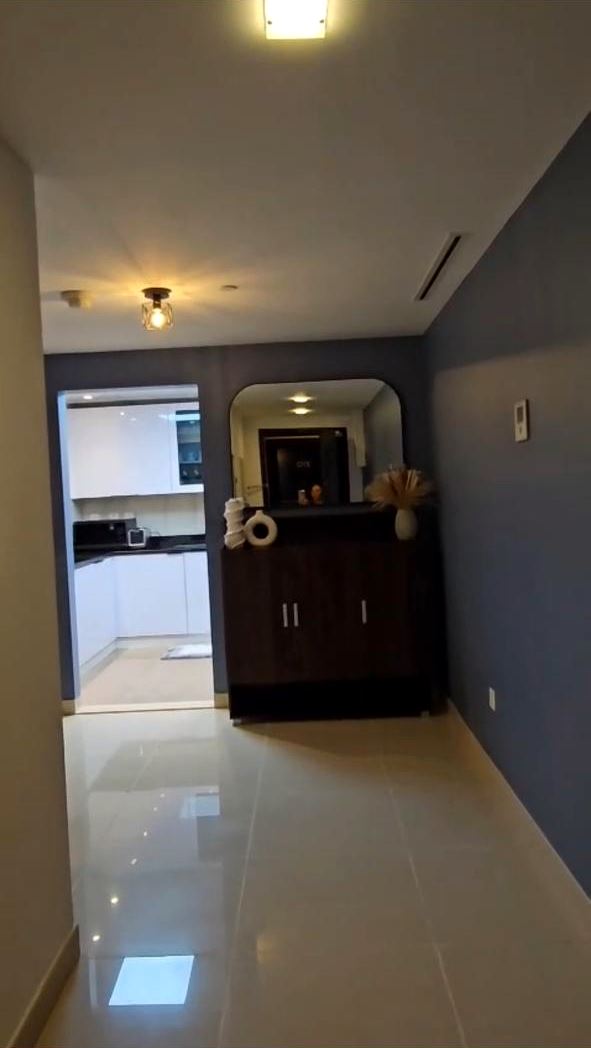 Apartment entrance hallway with polished floor tiles and painted walls