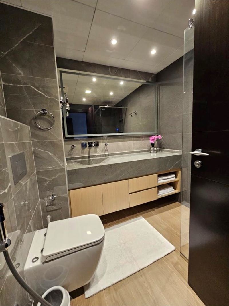 Bathroom with grey marble-effect wall tiles and timber-look floor tiles