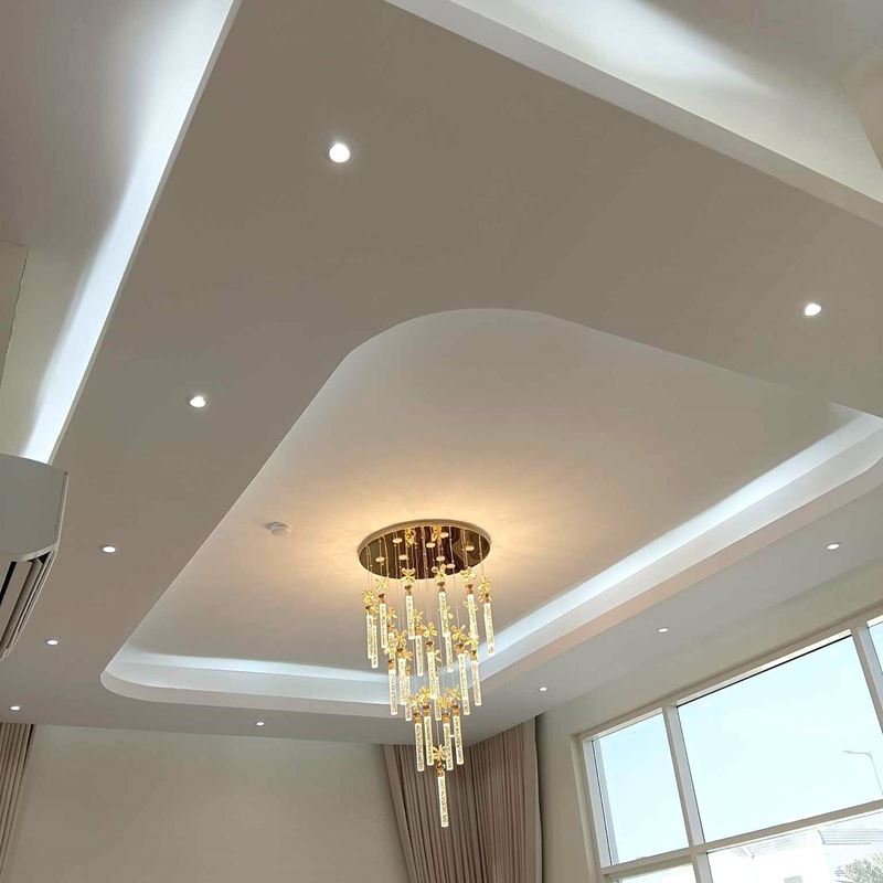 Curved gypsum ceiling with concealed cove lighting and chandelier