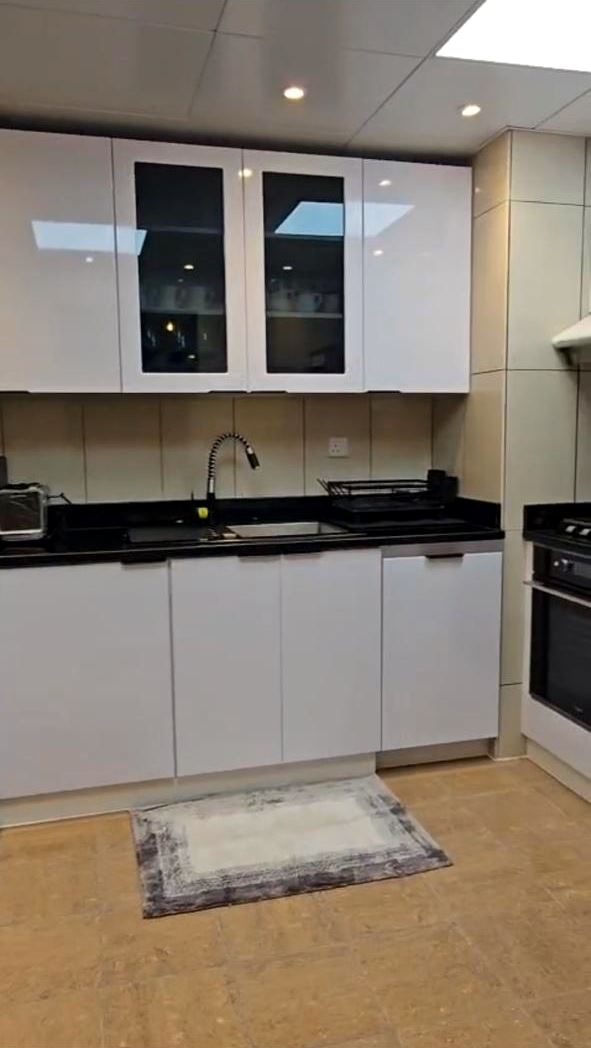 Kitchen with white gloss cabinets and black worktop