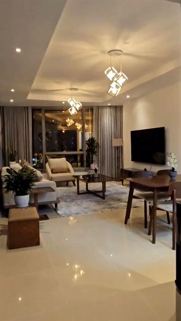 Living room with cove-lit gypsum ceiling, cube pendant lights and polished floor tiles