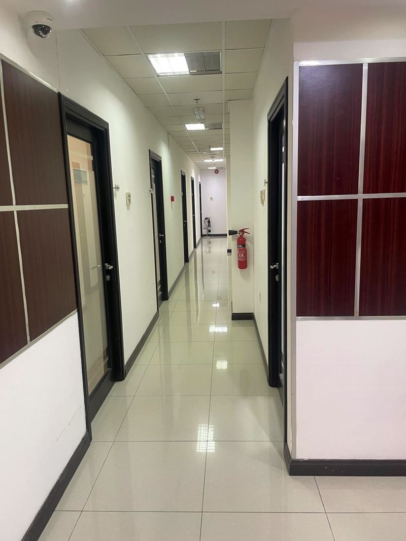 Commercial office corridor with suspended ceiling tiles and polished floor